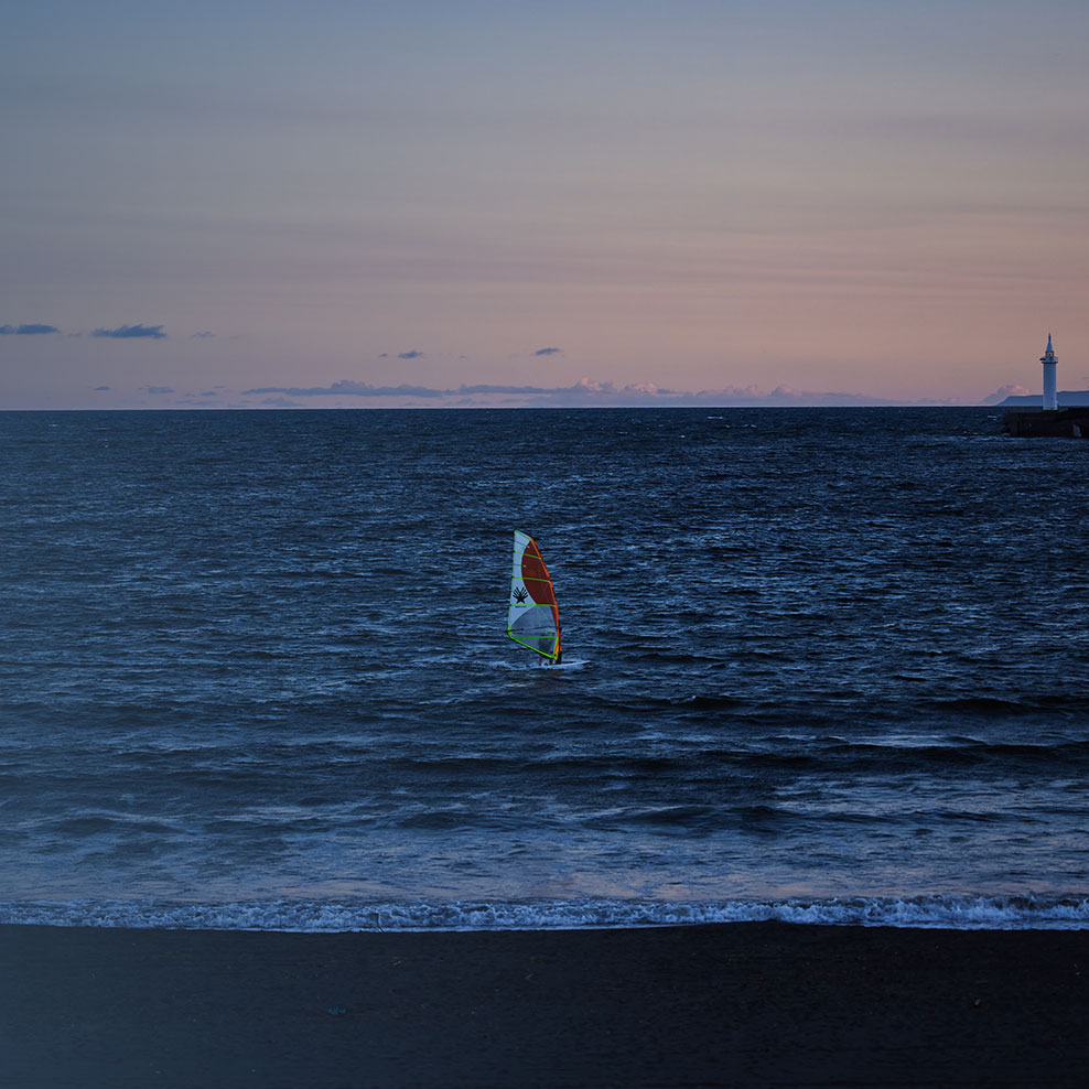 Evening scenery seen from UMITO, showing people doing marine sports at dusk